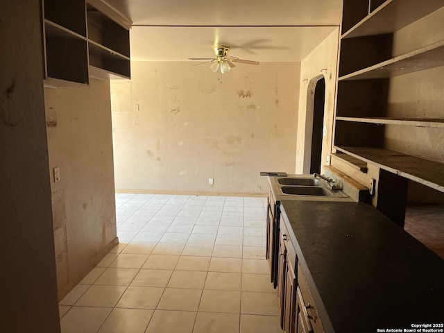 kitchen with light tile patterned floors, ceiling fan, and a sink