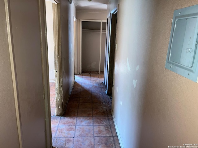 hallway featuring electric panel and dark tile patterned floors