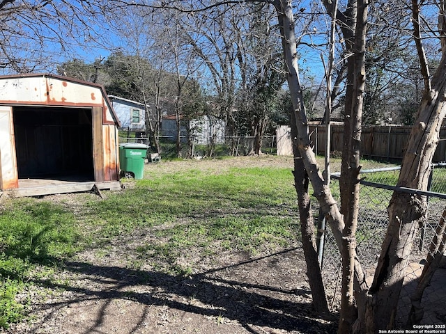 view of yard featuring a storage shed, fence, and an outdoor structure