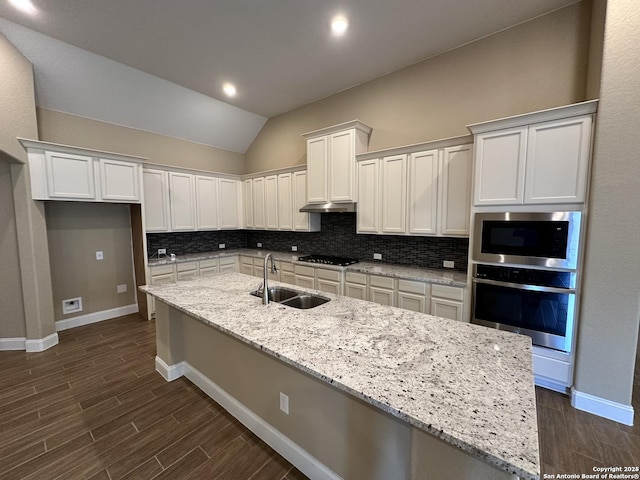 kitchen with black gas cooktop, light stone counters, white cabinets, and a sink