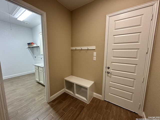 mudroom with attic access, light wood-type flooring, and baseboards