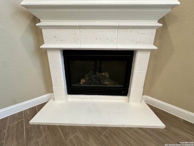 details with a fireplace, baseboards, and wood finished floors