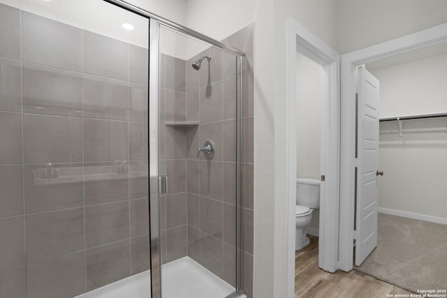 4338 Clarisse St, New Braunfels, TX 78130 - bathroom featuring a shower stall, toilet, a walk in closet, wood finished floors, and baseboards