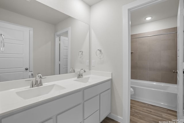 4338 Clarisse St, New Braunfels, TX 78130 - bathroom featuring wood finished floors, double vanity, toilet, and shower / bathtub combination