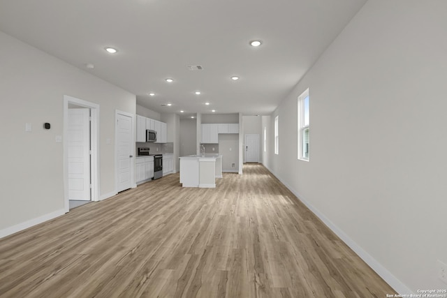 4338 Clarisse St, New Braunfels, TX 78130 - unfurnished living room with light wood-style flooring, baseboards, recessed lighting, and a sink
