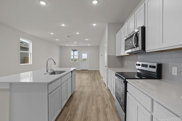 4338 Clarisse St, New Braunfels, TX 78130 - kitchen with appliances with stainless steel finishes, a sink, light wood finished floors, decorative backsplash, and light countertops