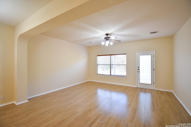 spare room featuring light wood-type flooring, baseboards, visible vents, and a ceiling fan