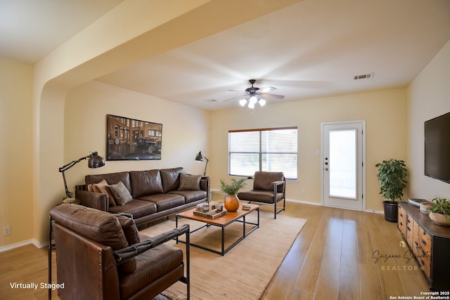 living room with ceiling fan, light wood-style flooring, visible vents, and baseboards