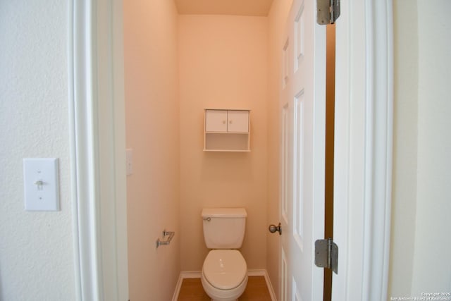 bathroom with toilet and baseboards