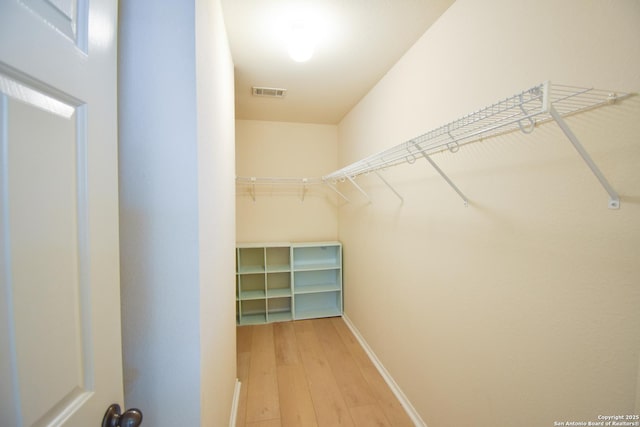 walk in closet with visible vents and wood finished floors