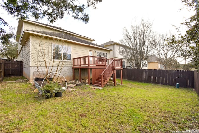 rear view of house with a fenced backyard, stairway, a lawn, and a wooden deck