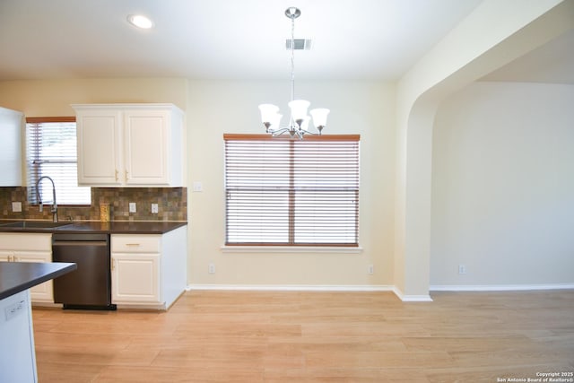 kitchen with dark countertops, visible vents, hanging light fixtures, white cabinets, and dishwasher