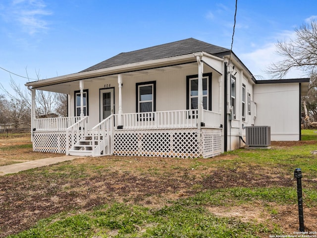 view of front of property featuring covered porch, a front yard, and cooling unit