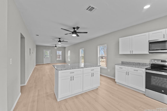 kitchen featuring white cabinets, light stone countertops, and stainless steel appliances