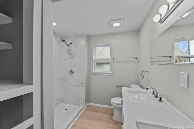 full bath featuring toilet, wood finished floors, a sink, and a wealth of natural light