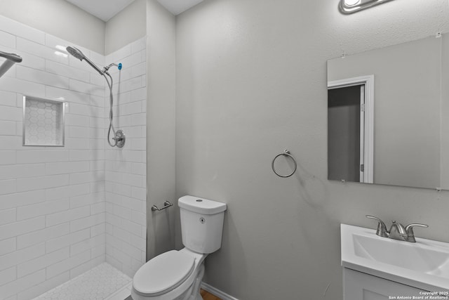 bathroom featuring a shower stall, baseboards, vanity, and toilet