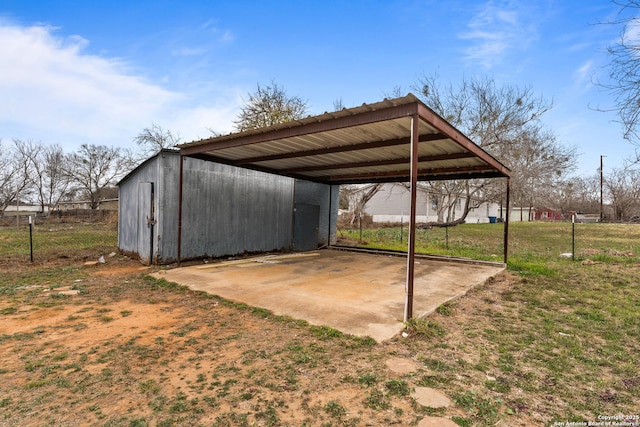 exterior space with a detached carport, fence, and dirt driveway