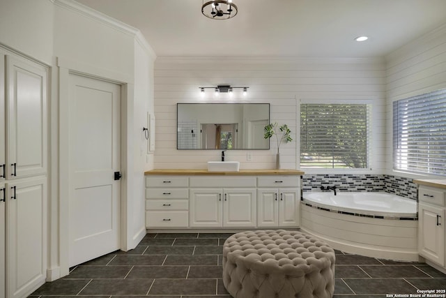 full bath featuring tile patterned floors, ornamental molding, a bath, and vanity