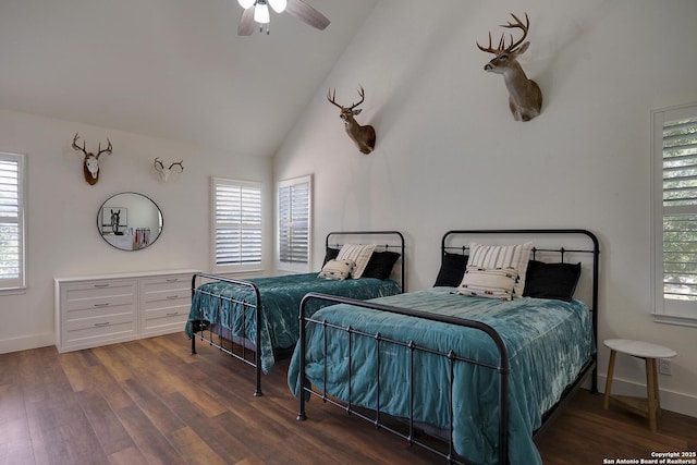 bedroom featuring multiple windows, baseboards, vaulted ceiling, and wood finished floors