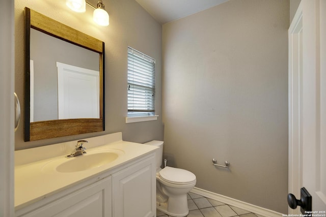 bathroom featuring baseboards, vanity, toilet, and tile patterned floors