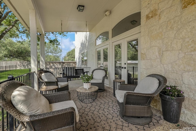 view of patio with french doors and fence