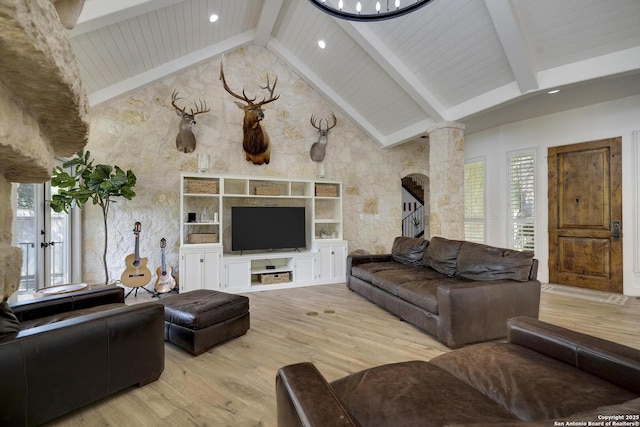 living area with stairway, wood finished floors, ornate columns, high vaulted ceiling, and beam ceiling