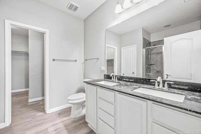 full bath featuring visible vents, a sink, toilet, and wood finished floors