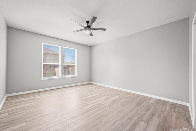 unfurnished room with light wood-style floors, ceiling fan, baseboards, and a textured ceiling