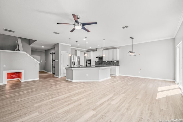 unfurnished living room with light wood-style floors, visible vents, ceiling fan, and ornamental molding