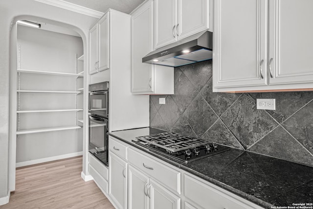 kitchen with under cabinet range hood, baseboards, light wood-style floors, white cabinets, and black appliances