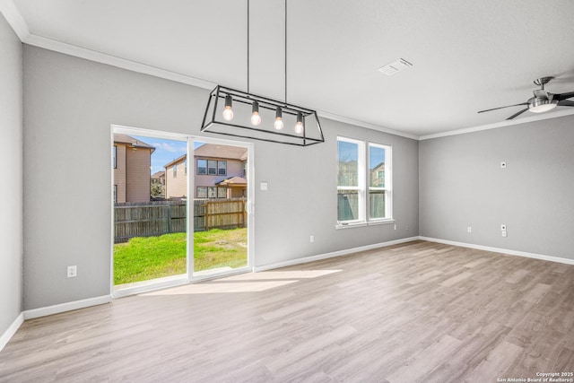 unfurnished dining area with light wood-type flooring, a healthy amount of sunlight, baseboards, and ornamental molding