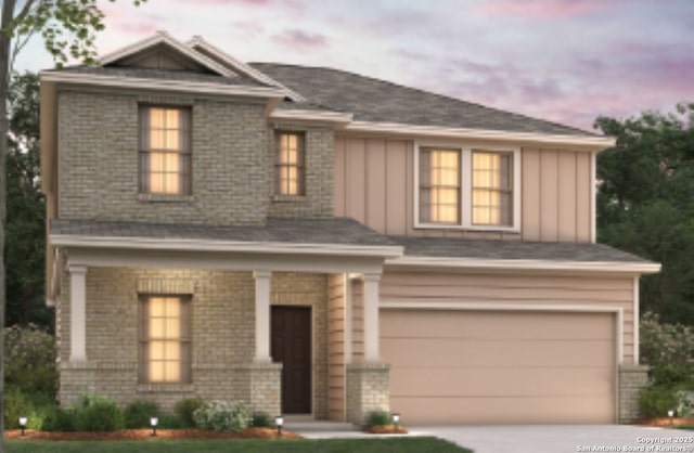 view of front of house with board and batten siding, brick siding, driveway, and a garage