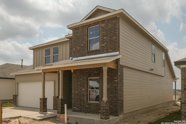 15482 Jake Xing, San Antonio, TX 78245 - view of front of property featuring a garage, brick siding, board and batten siding, and driveway