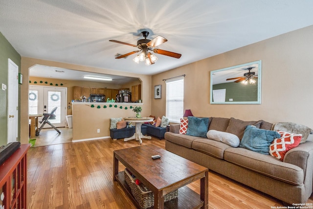 living area with ceiling fan and light wood finished floors