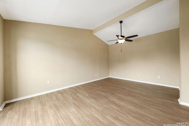 unfurnished room with ceiling fan, lofted ceiling with beams, baseboards, and wood finished floors