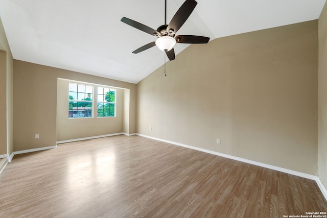 empty room with light wood-style floors, baseboards, and vaulted ceiling