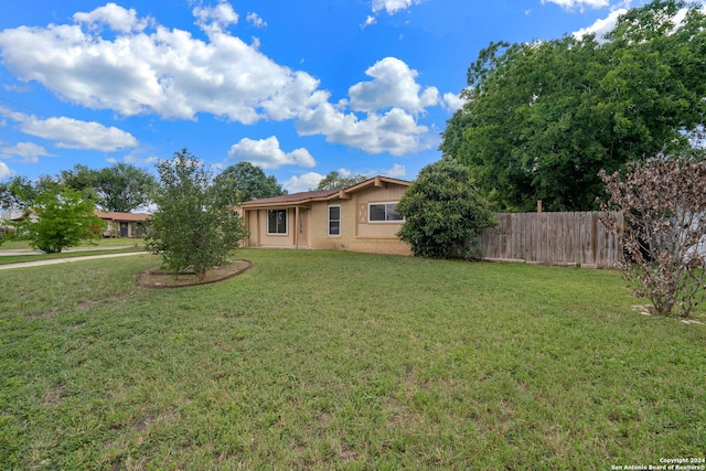 view of front of property with brick siding, fence, and a front lawn