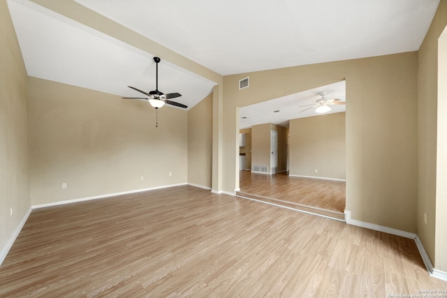 unfurnished room with light wood-style floors, lofted ceiling, visible vents, and ceiling fan