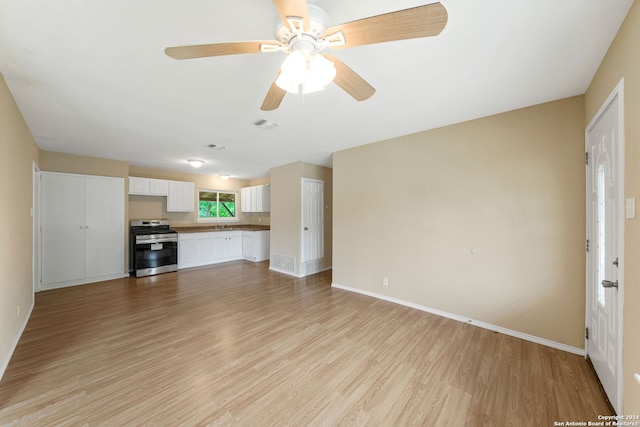 unfurnished living room with visible vents, ceiling fan, light wood-style flooring, and baseboards