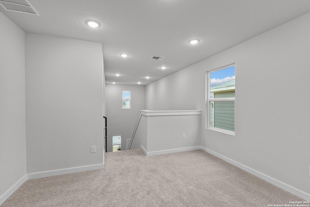 below grade area featuring carpet, visible vents, and baseboards