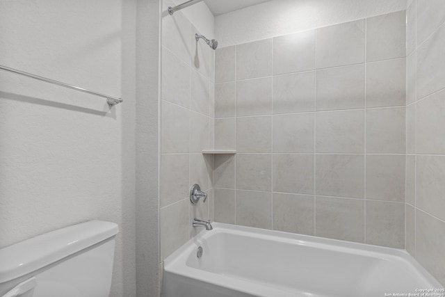 bathroom with toilet, shower / tub combination, and a textured wall