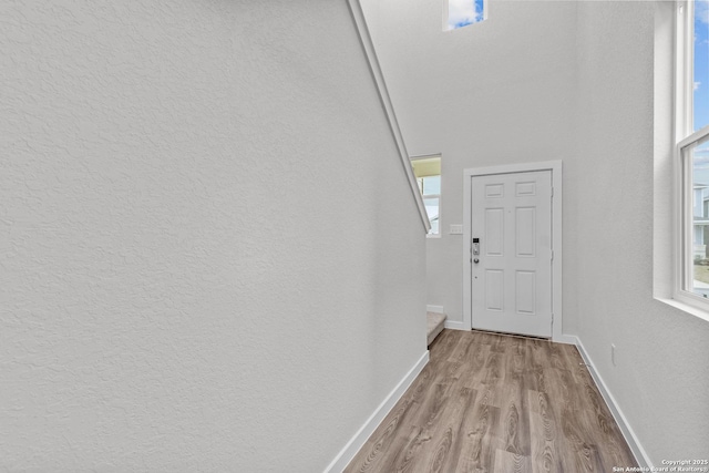 doorway to outside featuring light wood-style flooring and baseboards