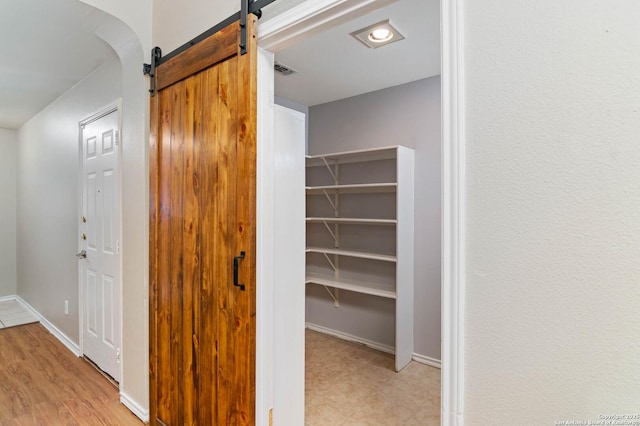 interior space featuring a barn door, visible vents, and baseboards