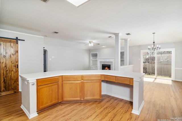 kitchen with brown cabinets, a kitchen island, light countertops, and open floor plan