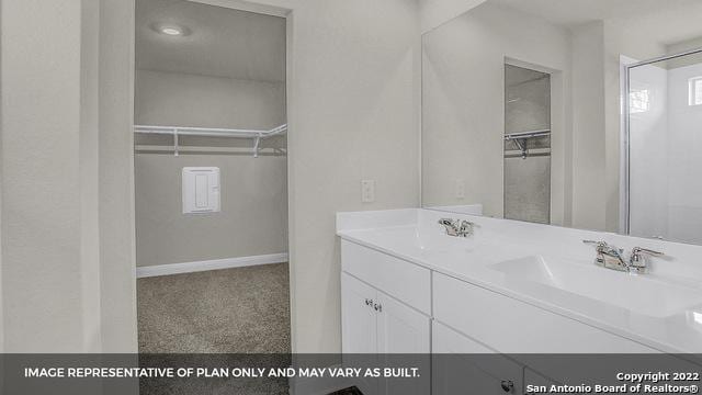 full bath featuring a sink, a spacious closet, and double vanity