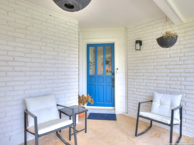 entrance to property featuring brick siding