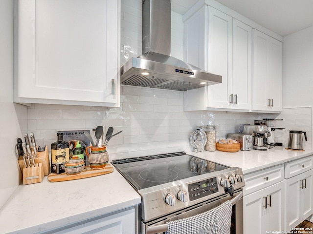 kitchen with white cabinetry, light countertops, wall chimney range hood, and stainless steel electric stove