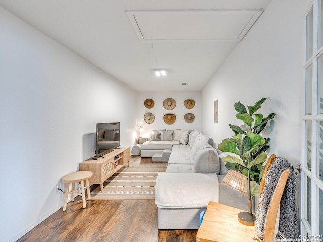 living area featuring wood finished floors and attic access