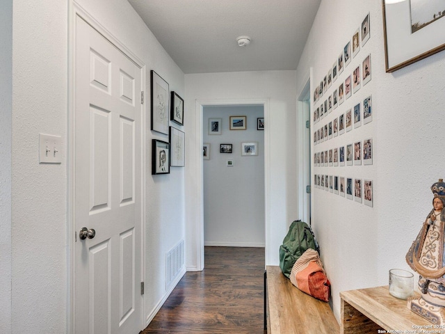 corridor featuring dark wood-style flooring and visible vents