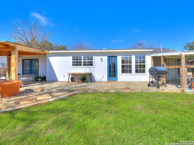 rear view of property with a lawn and french doors